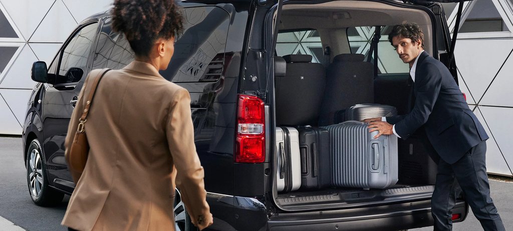Rear of the Citroën SpaceTourer open as people load multiple suitcases, showing generous cargo capacity